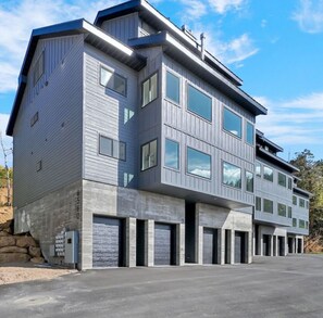 Un edificio moderno de varios pisos con techo plano, ventanas grandes y fachada de hormigón.