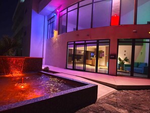 Exterior modern d'un hotel amb piscina, grans finestres i una zona de recepció.