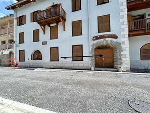 A building with multiple windows, a wooden balcony, and a stone archway. - 1st floor, terrace, tv, 82m², Serre Chevalier (SERRE CHEVALIER)
