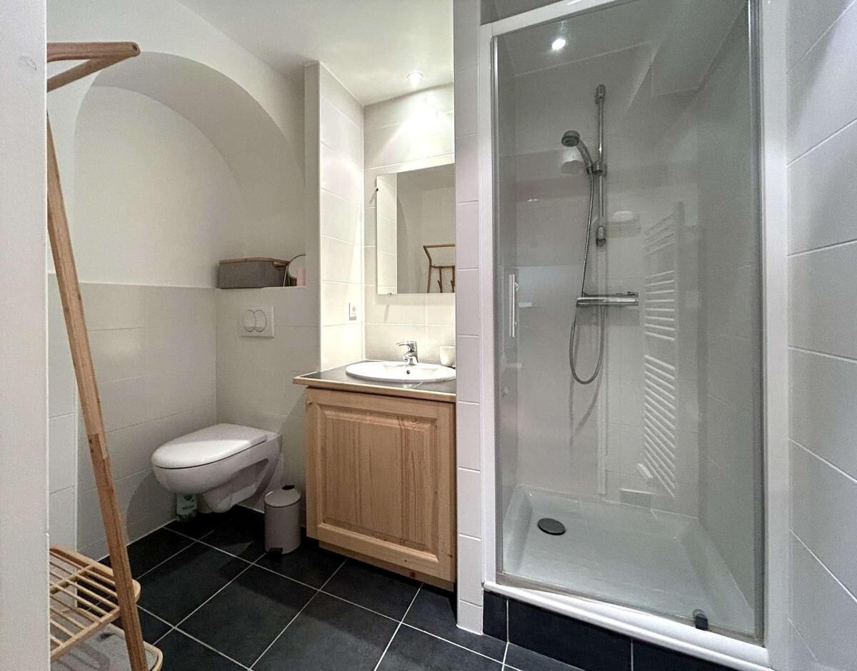 A bathroom with a toilet, sink, and glass-enclosed shower.