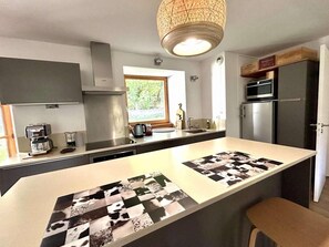 A modern kitchen with a central island, built-in appliances, and a large window. - 1st floor, terrace, tv, 82m², Serre Chevalier (SERRE CHEVALIER)