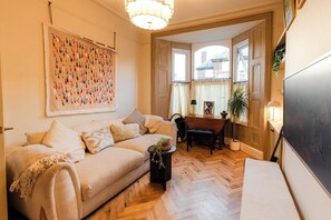 Een gezellige woonkamer met een bank, een salontafel en een eethoek met een tafel en stoelen.