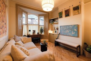 A cozy living room with a sofa, bench, and a painting on the wall.