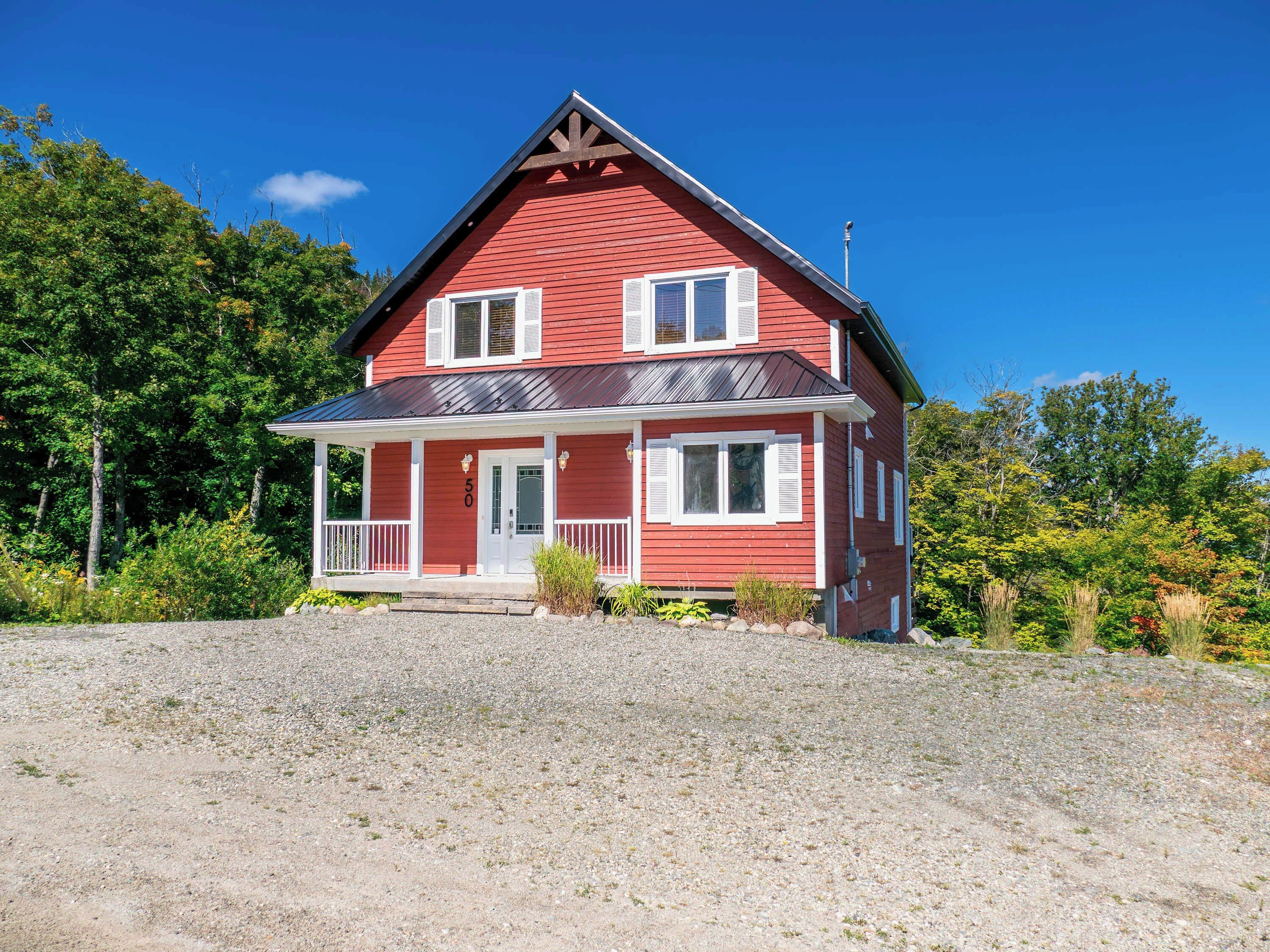 A red house with a porch and a number '50' on the door.