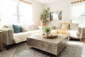 A living room with a sofa set, a coffee table, and a painting on the wall. - Cozy 3-Level Chattanooga Retreat with Relaxing Outdoor Spaces (Chattanooga)