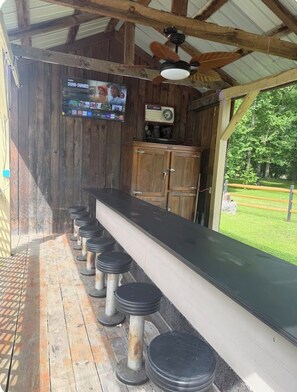 Eine rustikale Bar mit Holzwänden, einer langen Theke und mehreren Hockstühlen.