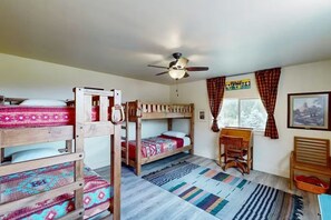 A room with bunk beds, a desk, a chair, a window with curtains, and a ceiling fan. - Pine Croft on Rio Grande  | 27 Mi to Wolf Creek (South Fork)