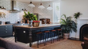 A kitchen with a central island, bar stools, a stove, and a large window. - The Gums 40 wonderfully private country escape (Korweinguboora)