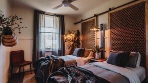 A bedroom with two beds, a ceiling fan, a window with curtains, a plant, and a wall-mounted light fixture. - The Gums 40 wonderfully private country escape (Korweinguboora)