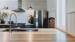 Una cocina moderna con un refrigerador de acero inoxidable, una estufa a gas y un lavaplatos.