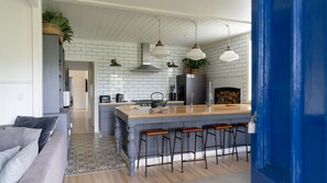 A modern kitchen with a central island, bar stools, and pendant lighting. - The Gums 40 wonderfully private country escape (Korweinguboora)