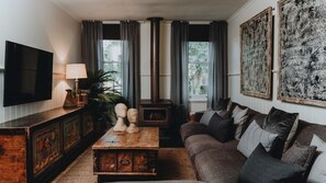 A living room with a television, a fireplace, a sofa, and artwork on the walls. - The Gums 40 wonderfully private country escape (Korweinguboora)
