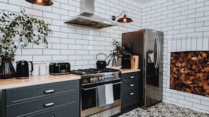 Eine moderne Küche mit einem Edelstahl-Kühlschrank, einem Gasherd und einem schwarzen Toaster.