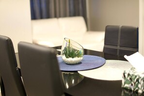 A dining area with a round table, chairs, and a glass terrarium on the table center.