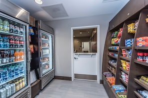A corridor with refrigerated beverage dispensers on the left and snack shelves on the right.