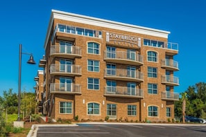 A Staybridge Suites building with multiple balconies, large windows, and a brick facade. - Free Breakfast | ADA Studio Suite w/ Roll-in Shwr (Mt. Pleasant)