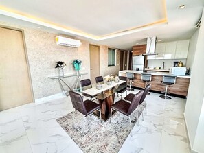 A modern dining area with a marble floor, a glass table, and dark chairs. - Depto Mazatlán Golden View by Interhome (Mazatlán)