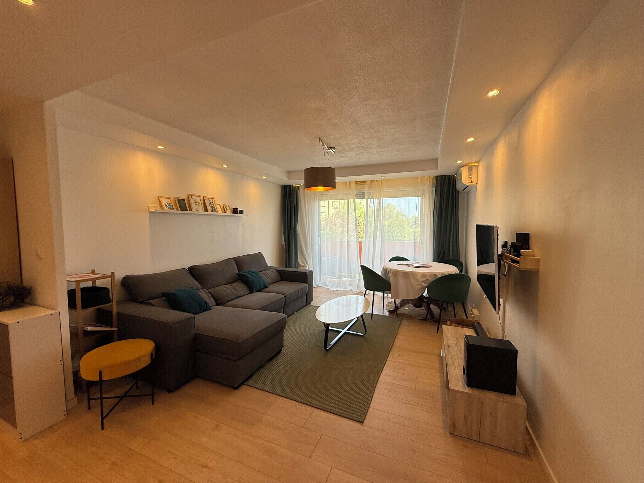 A modern living room with a sofa, a coffee table, and a dining area with chairs.