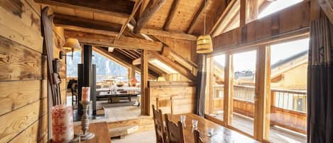 Un interior de madera con comedor, ventanas grandes y vistas al exterior.