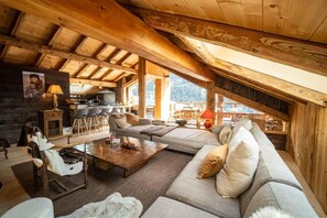 A cozy loft-style room with a wooden ceiling, a sofa set, a dining table, and a kitchen area. - Chalet, 150m from ski slopes, 3rd floor, view panoramic, terrace, fireplace or stove, 250m² (Champagny-en-Vanoise)