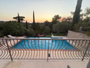 A swimming pool with a metal railing, surrounded by trees and a stone wall. - Villa Saint Raphael in peaceful Valescure (Golf course and beach nearby) (saint raphael)