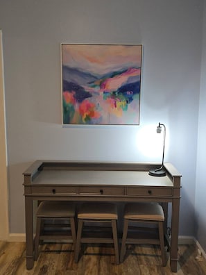 A desk with a lamp and a colorful abstract painting above it. - The Market House exudes charm and comfort.  It has a large open concept and all the amenities of home. (Ashland)