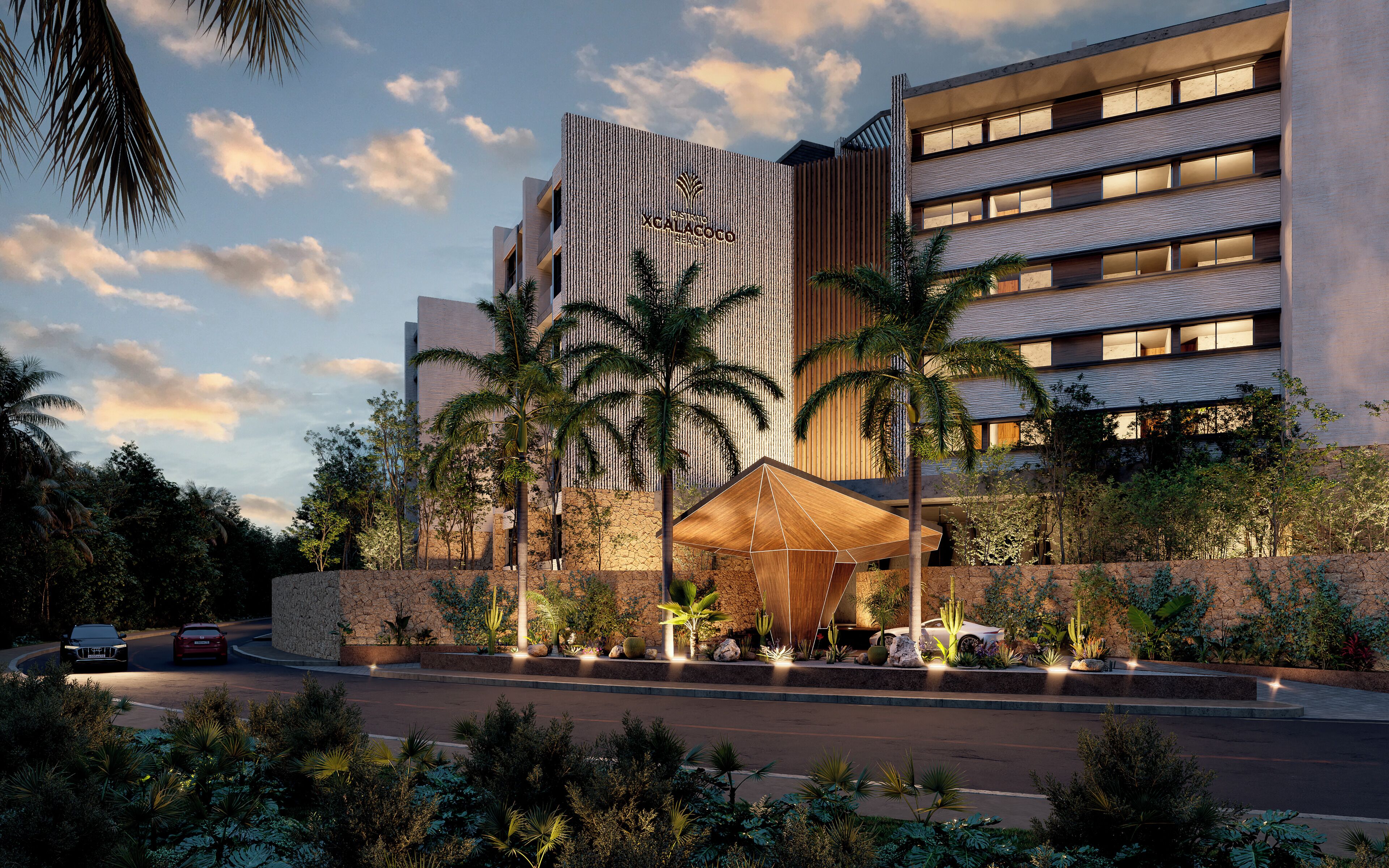 Un hôtel moderne doté d’une entrée imposante, d’une façade en pierre et d’un espace extérieur bien éclairé agrémenté de palmiers.