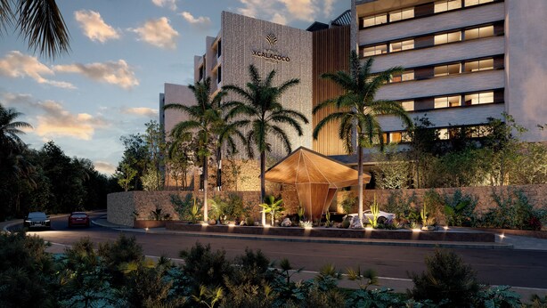 Un hôtel moderne doté d’une entrée imposante, d’une façade en pierre et d’un espace extérieur bien éclairé agrémenté de palmiers.