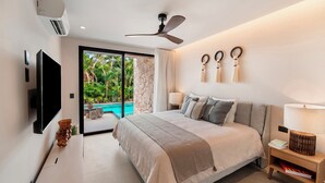 Une chambre moderne avec un grand lit, un ventilateur de plafond, une télévision et une vue sur une piscine.