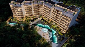 Un hôtel à plusieurs étages doté d’espaces de détente en plein air et d’une piscine.
