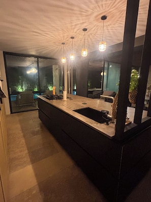A modern kitchen with a large island, pendant lights, and a view of the outdoors. - Exceptional Villa, Arcachon Bay, Infinity Pool (Le Teich)