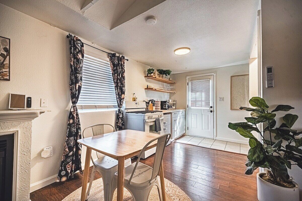 A kitchen with a dining table, chairs, a microwave, and a coffee maker.