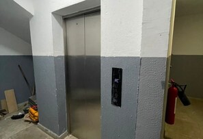 Un ascensor con un extintor de incendios sujeto a la pared a su lado.