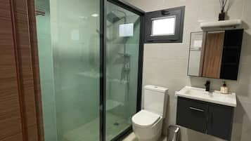 Comfort appartement, patio | Badkamer | Een douche, gratis toiletartikelen, een haardroger, pantoffels
