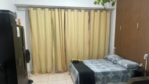 A bedroom with a bed, a wardrobe, a desk, and a plant. - Lapa Heart Studio (Rio de Janeiro)