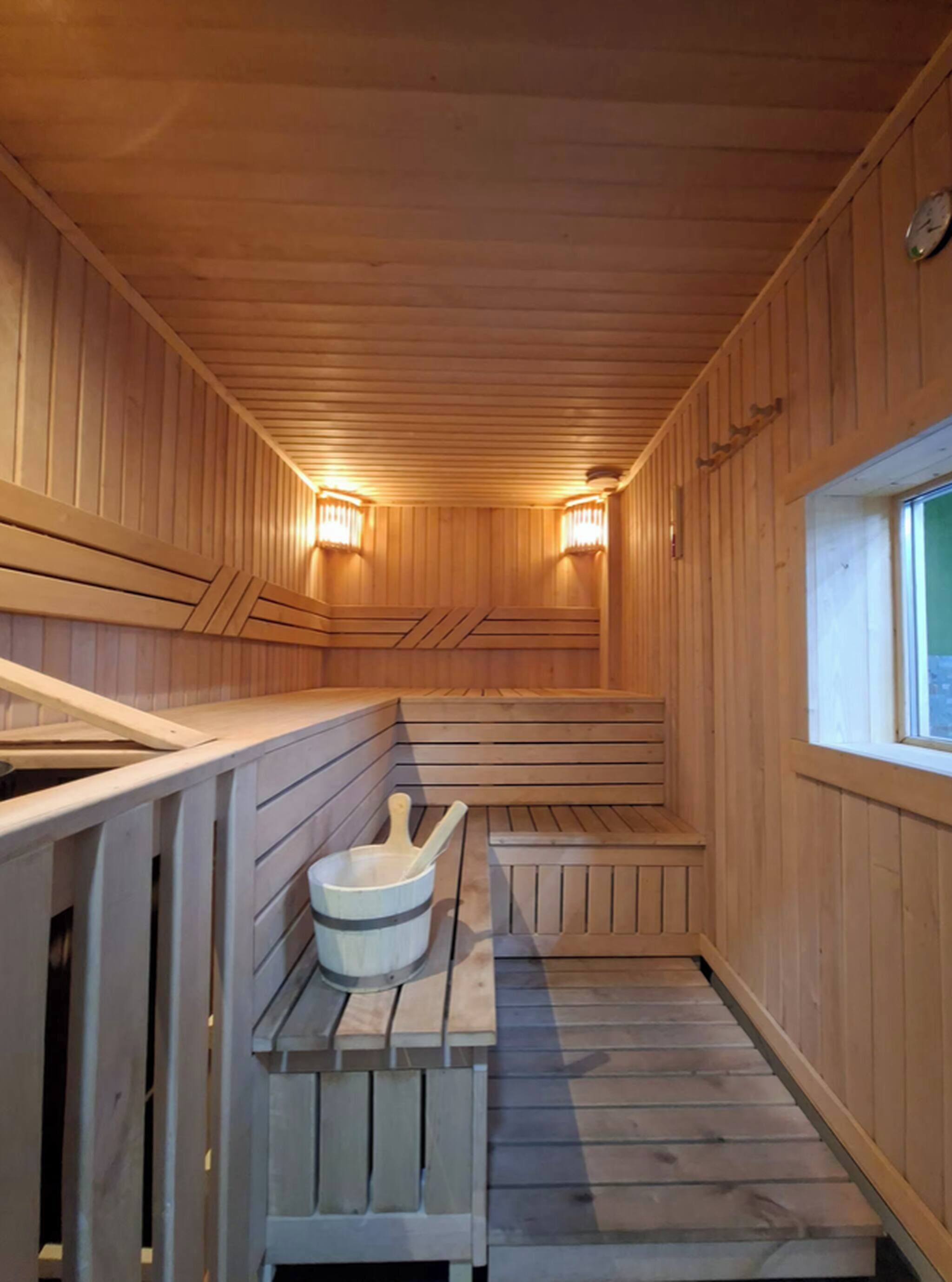 A sauna with wooden benches and a stone basin.