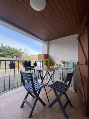 Ein Balkon mit zwei Stühlen, einem kleinen Tisch und einem Blumentopf.