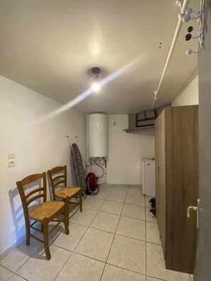 Um quarto com soalho em mosaico, teto branco, armário de madeira e radiador branco.