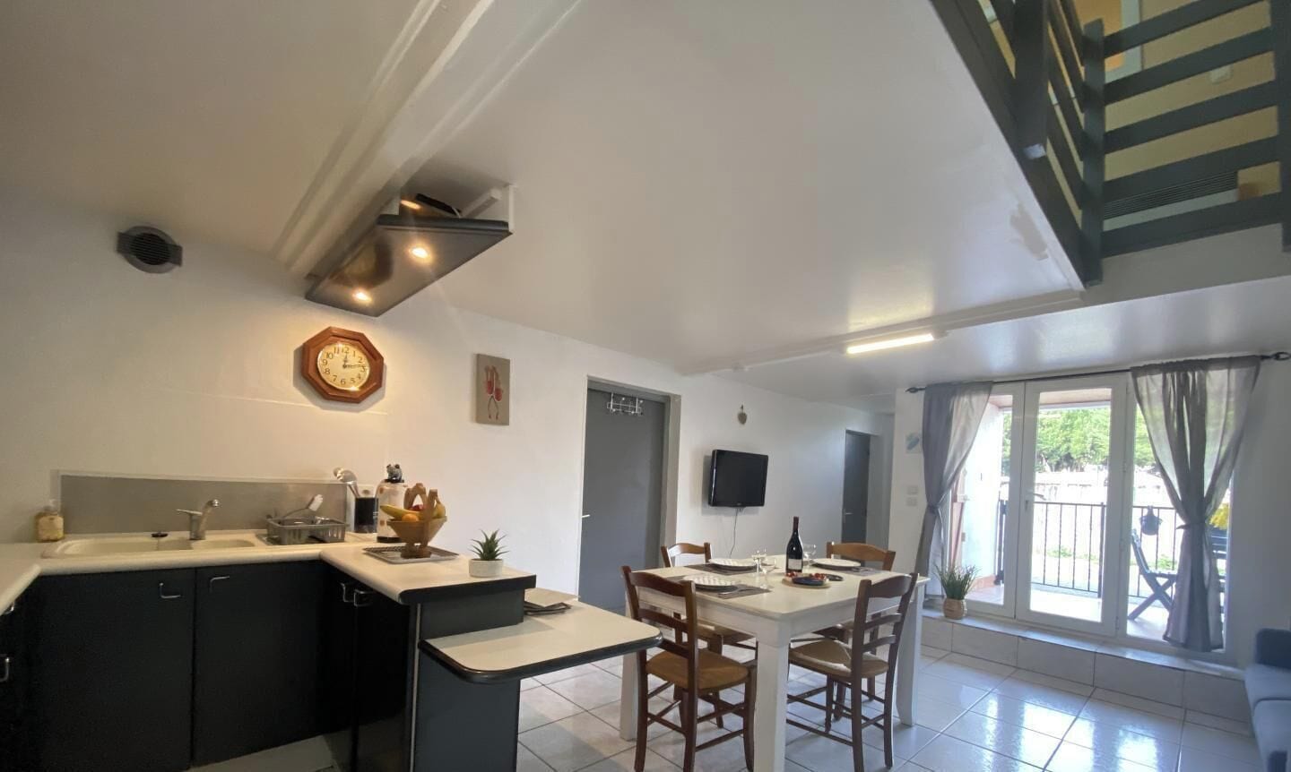 Una cocina moderna con comedor, estufa integrada y televisor de pantalla plana.