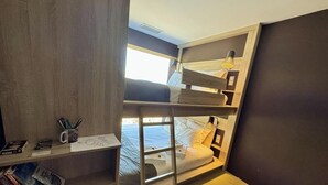 A bunk bed with a desk and chair, a window, and a shelf with books and a mug. - Lodge 2 - Extreme Nomad (CASES DE PENE)