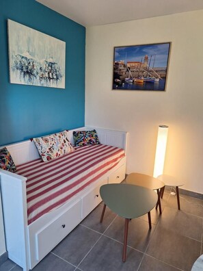 A room with a bed, a chair, a table, and two paintings on the wall. - The Birds of Paradise (VILLELONGUE DELS MONTS)