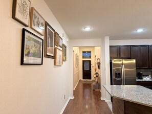 A kitchen with a stainless steel refrigerator, wooden cabinets, and a granite countertop. - Cozy Katy Getaway • 5 Min to Shops & Dining (Katy)