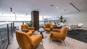 A modern lounge area with seating and a view of the city. - District 3704 (Miami)