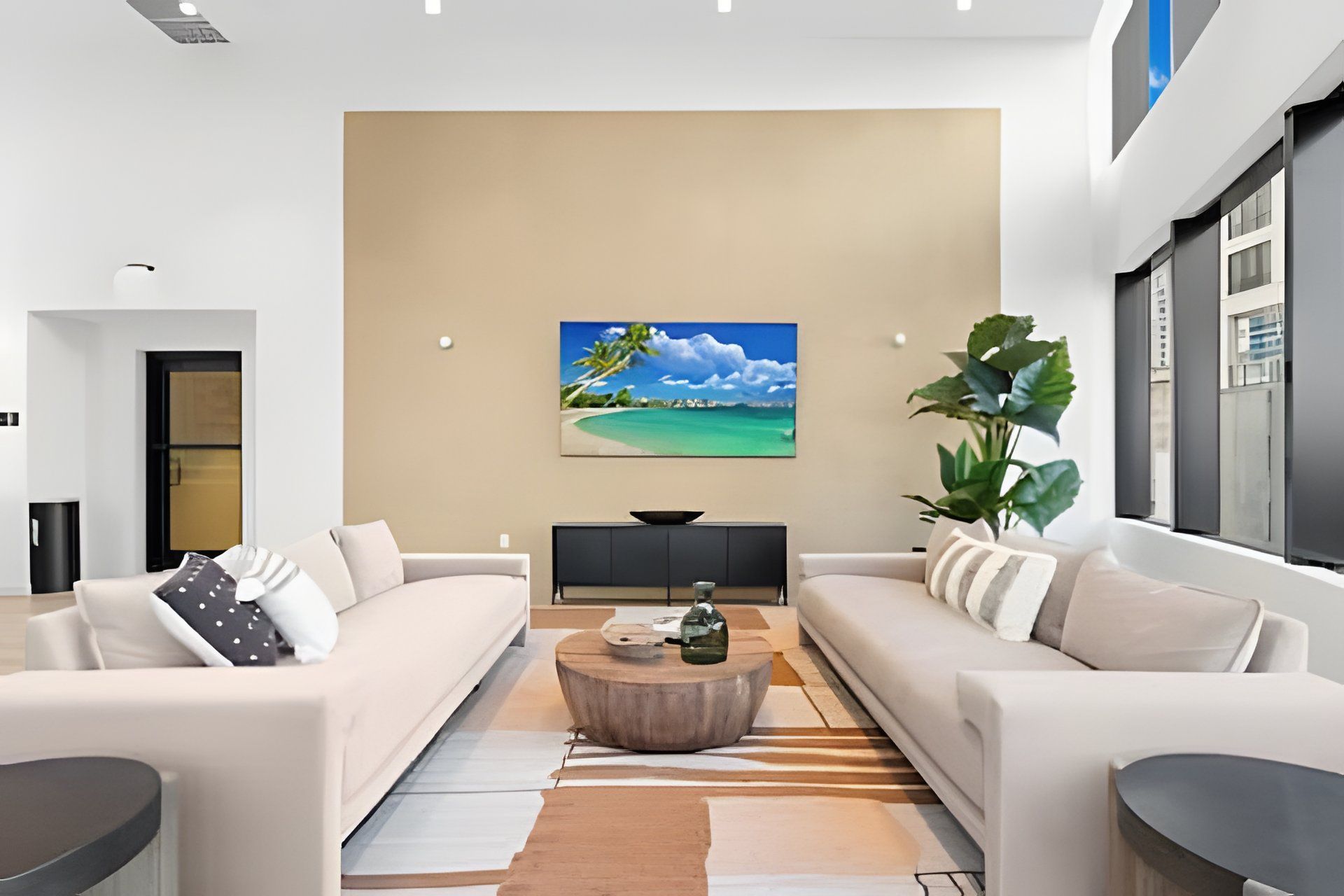 Een moderne woonkamer met twee banken, een salontafel en een schilderij aan de muur.