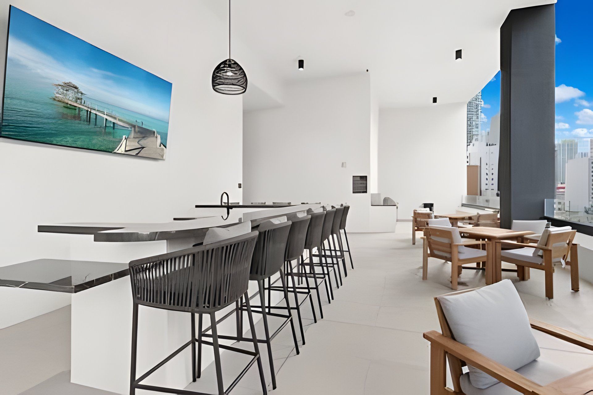 Cozinha moderna com balcão, espaço para refeições e vista para a cidade.