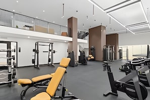 A modern gym with various exercise equipment, a mezzanine level, and a spacious layout. - District 225 - Rooftop Pool - Gym - Parking - Downtown Miami (Miami)