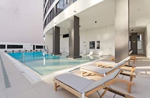 Ein Innenpool mit Liegestühlen und modernem Architekturstil.