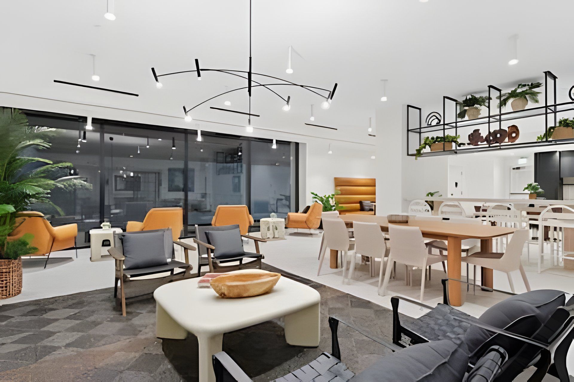 Ambiente moderno com área de jantar, assentos e cozinha.