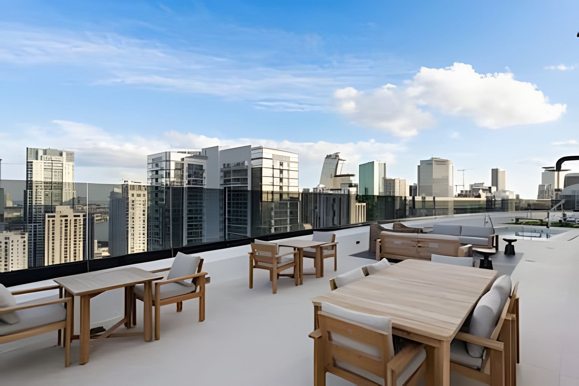 A rooftop terrace with outdoor seating and a city skyline view.