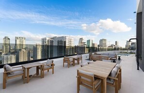 A rooftop terrace with outdoor furniture, a pool, and a city skyline view. - District 225 - Rooftop Pool - Gym - Parking - Downtown Miami (Miami)